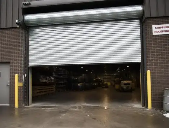 Large rolling steel commercial overhead door at a warehouse loading dock