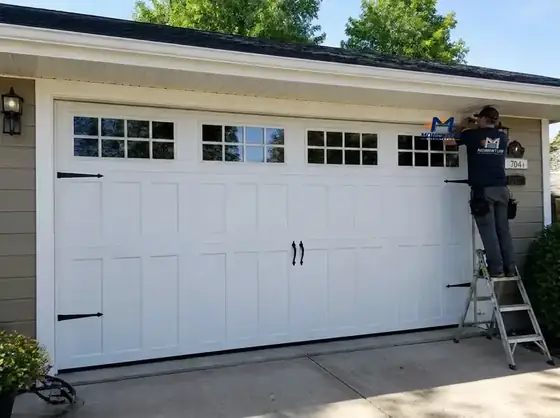 New white carriage-style sectional garage door being installed on a Charlotte area home