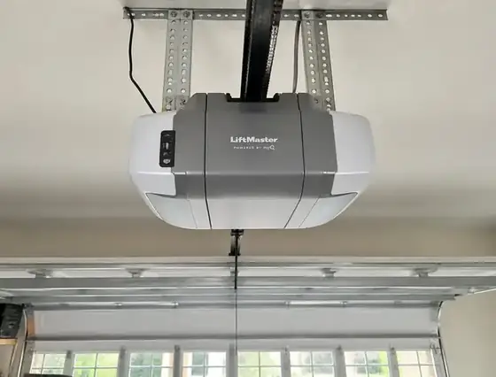 LiftMaster belt-drive garage door opener motor unit mounted to the ceiling above a sectional door