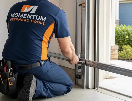 Momentum technician adjusting a residential garage door track with a wrench in a Charlotte NC garage